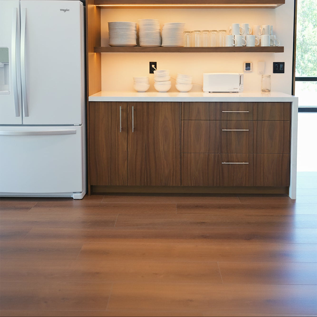 Modern kitchen with wooden cabinets, reddish wood LVP, white appliances, and open shelves.