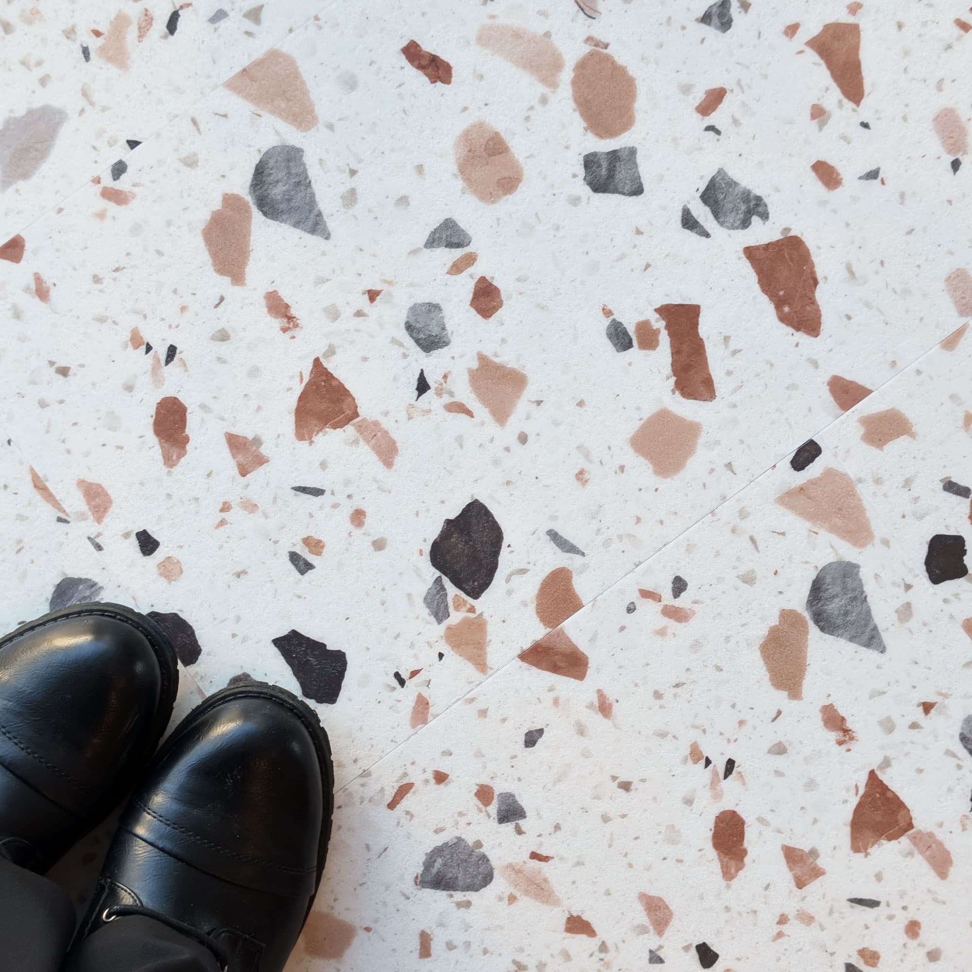 Allure terrazzo Ultima Blush flooring with black shoes