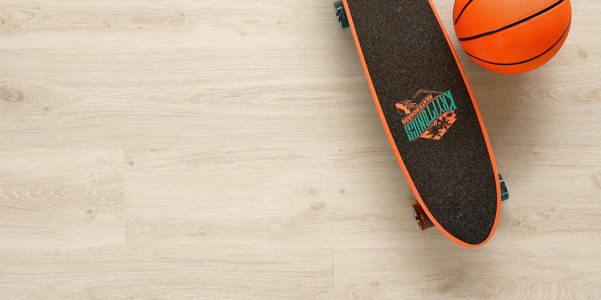 Allure luxury vinyl plank flooring in Soft Oak Sand installed floor view from above with skateboard and basketball