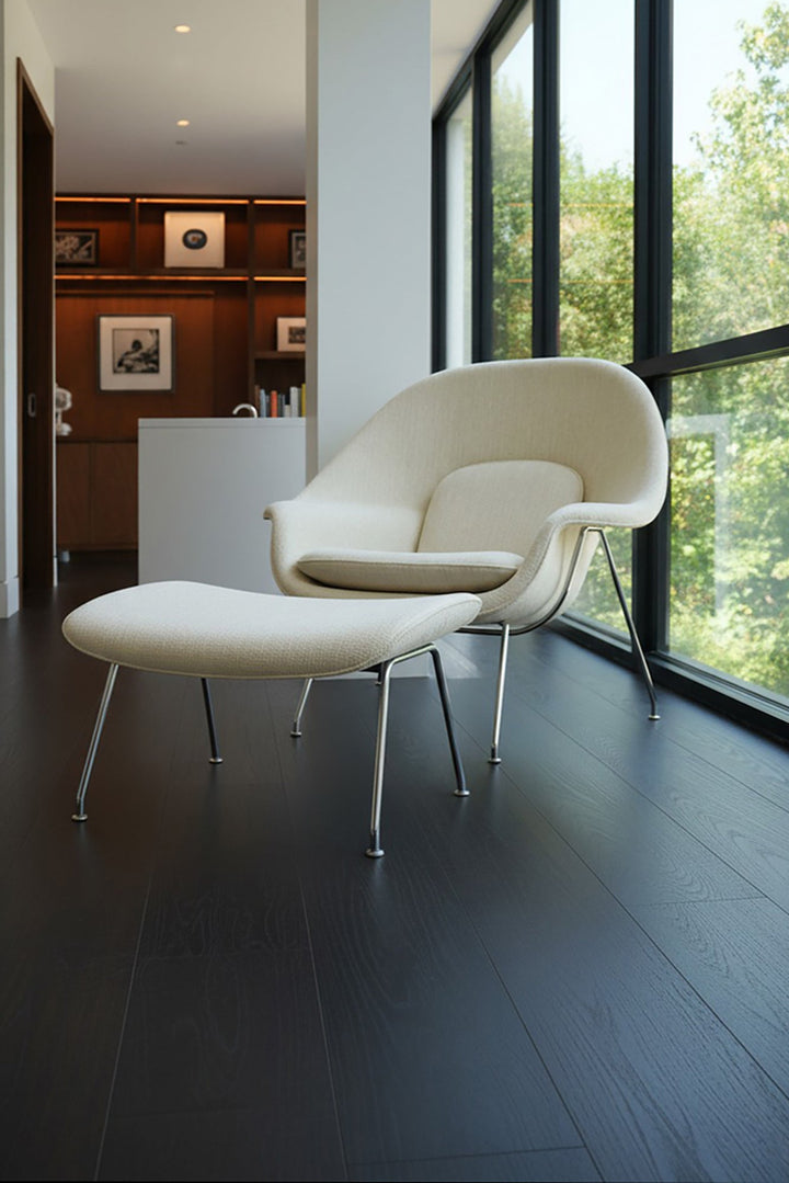 Modern white chair with ottoman in a room with velvet mocha Allure LVP floors and large windows