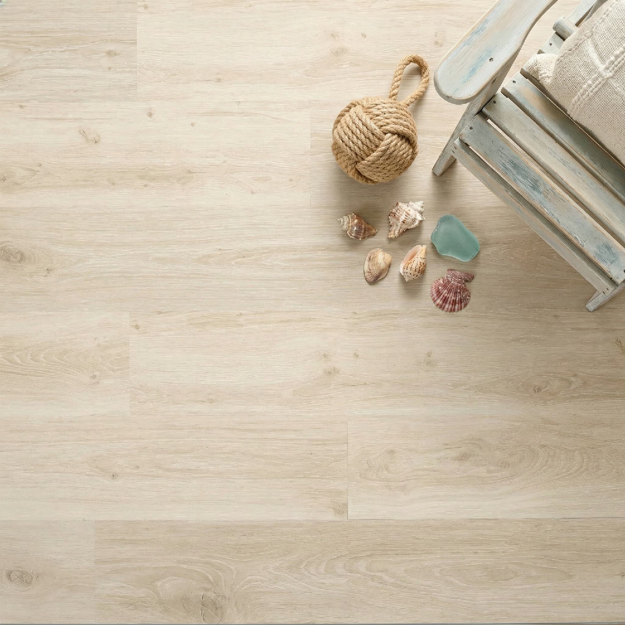 Wooden floor with a rope ball and seashells on a light wooden surface