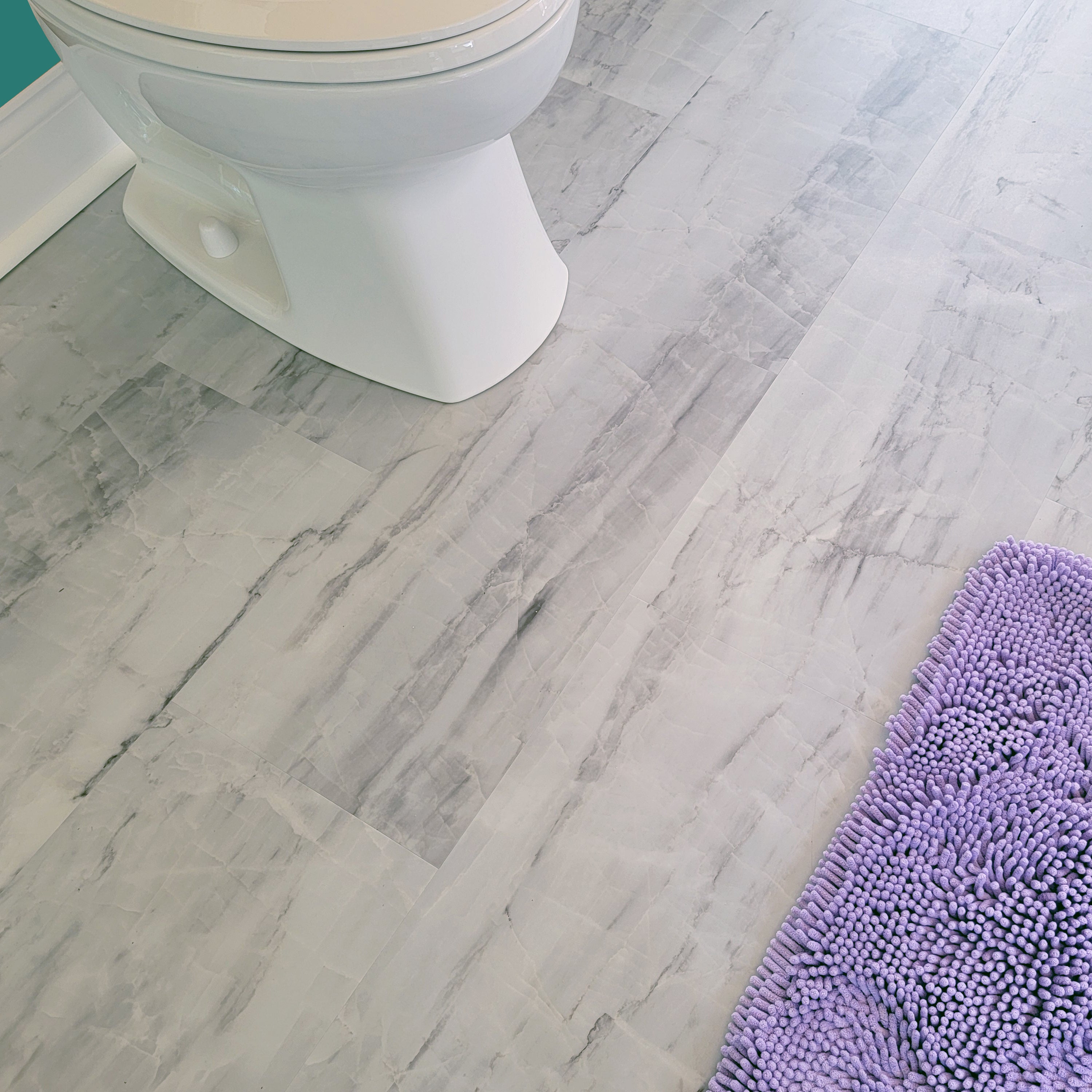 Marble vinyl tiles in a bathroom with toilet and rug