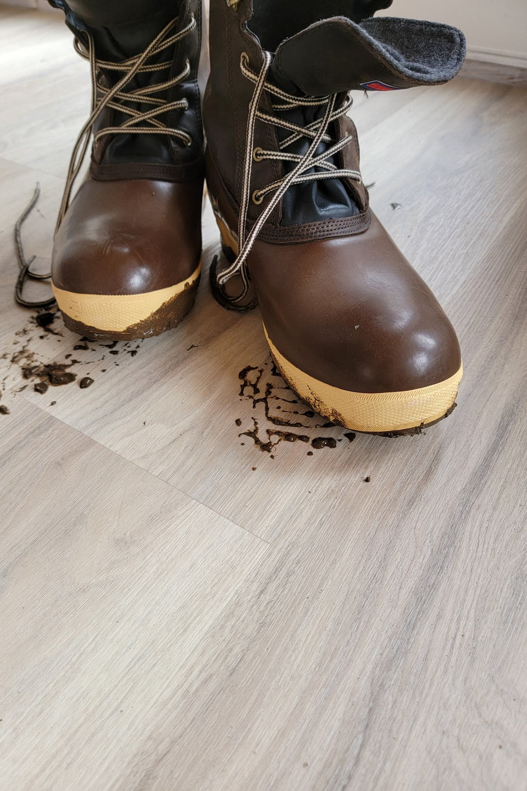 A pair of muddy fishing boots on Allure luxury vinyl plank flooring