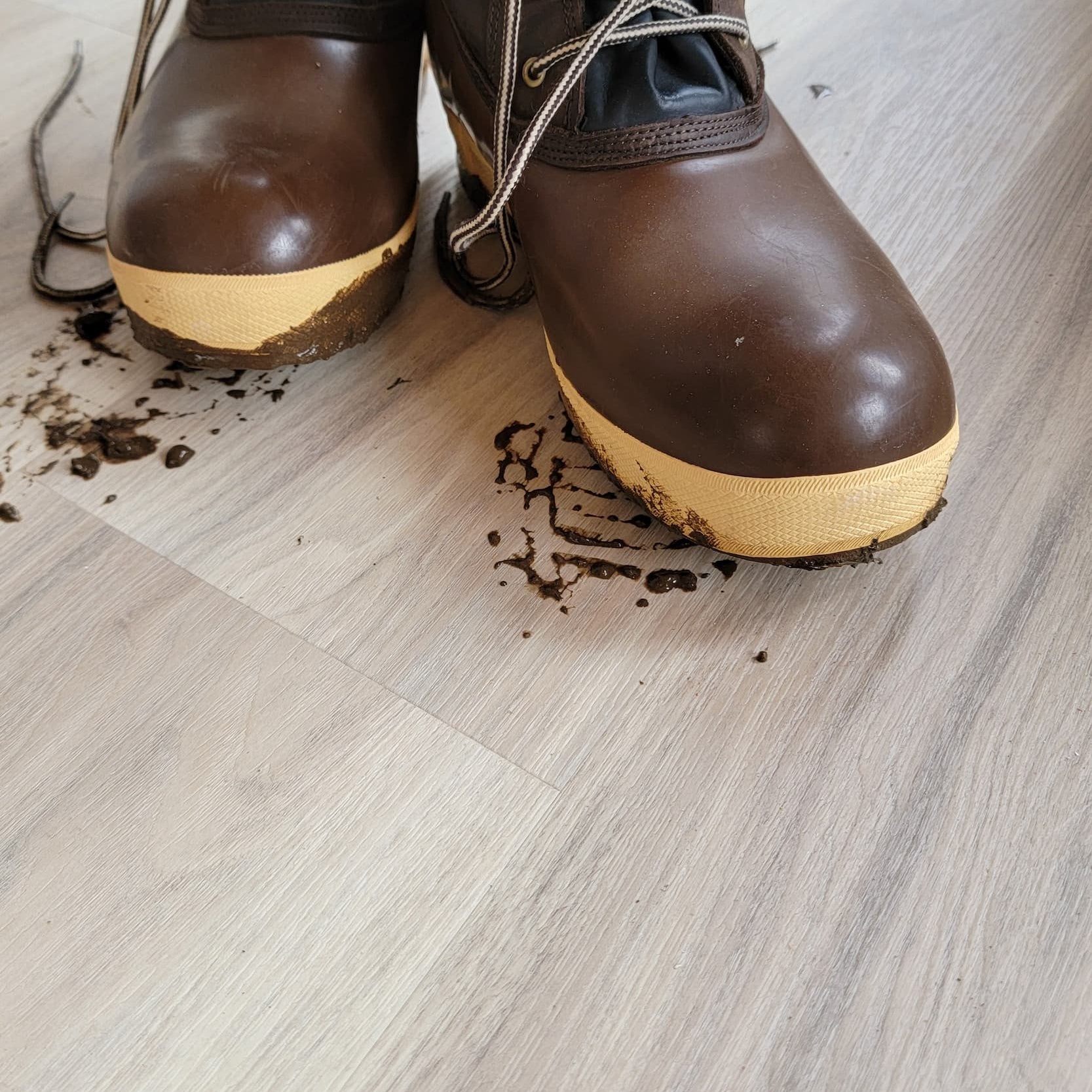 A pair of muddy fishing boots on Allure luxury vinyl plank flooring