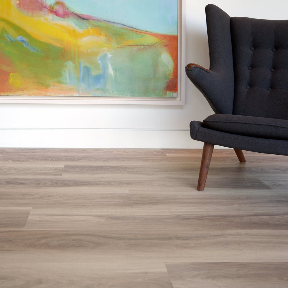 Allure luxury vinyl plank with painting on white wall and charcoal mid-century modern chair
