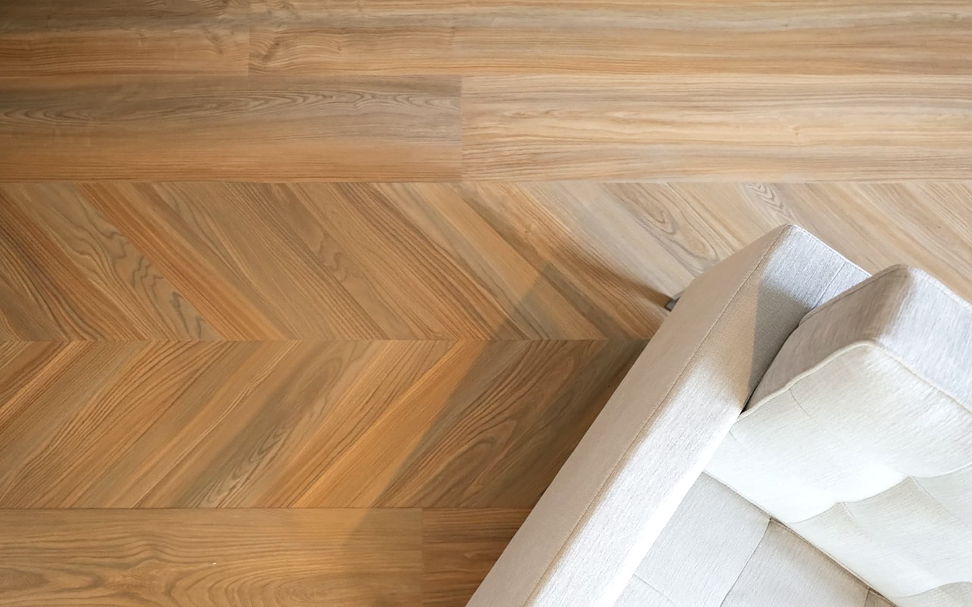 Chevron Flooring in peach crips pine LVP with white modern chair