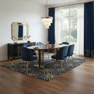 Dining room with round table and blue chairs on a patterned rug.