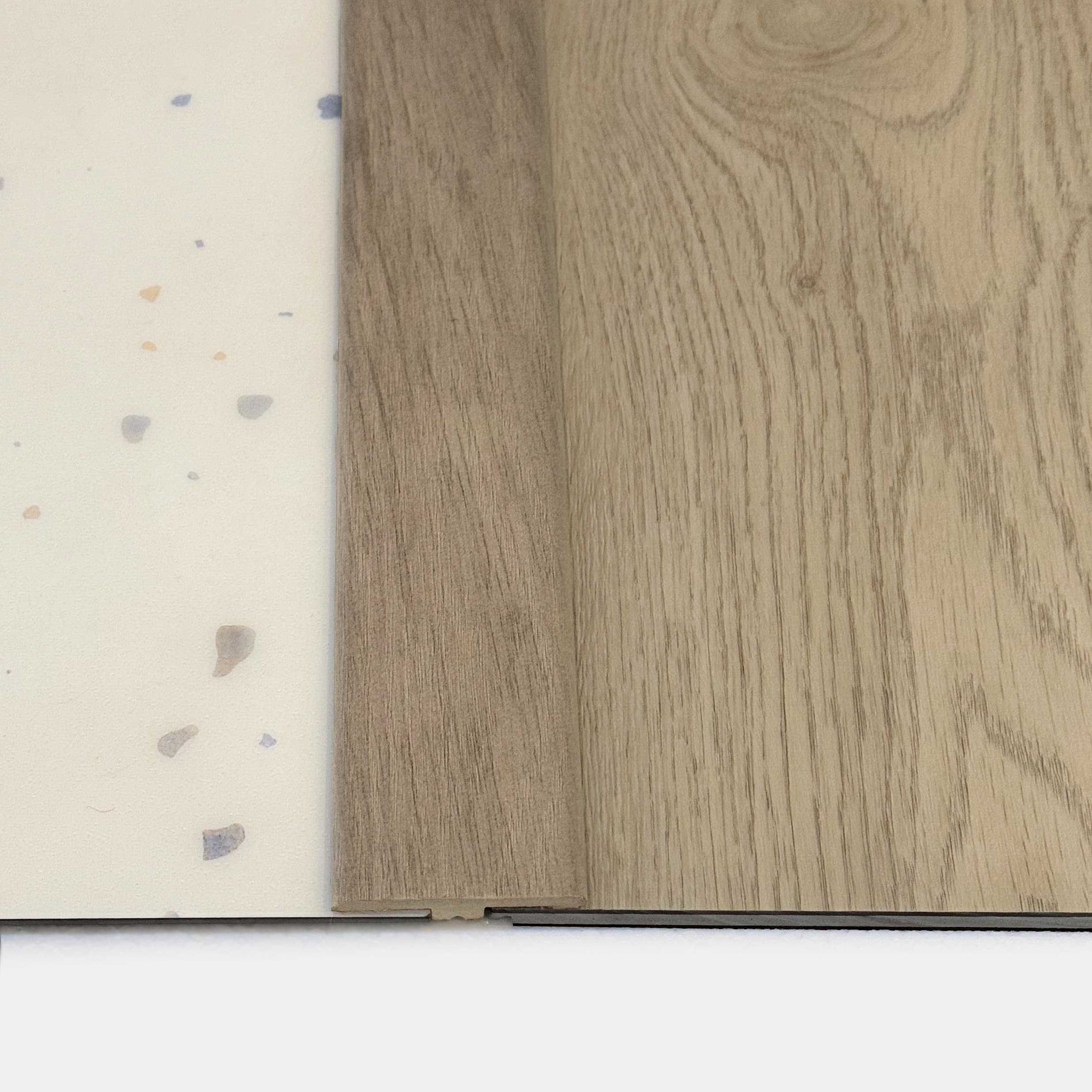 a cross section of T molding transition strip between 2 different vinyl flooring pieces.