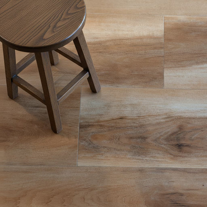Close up of hickory wood look LVP flooring with small stool