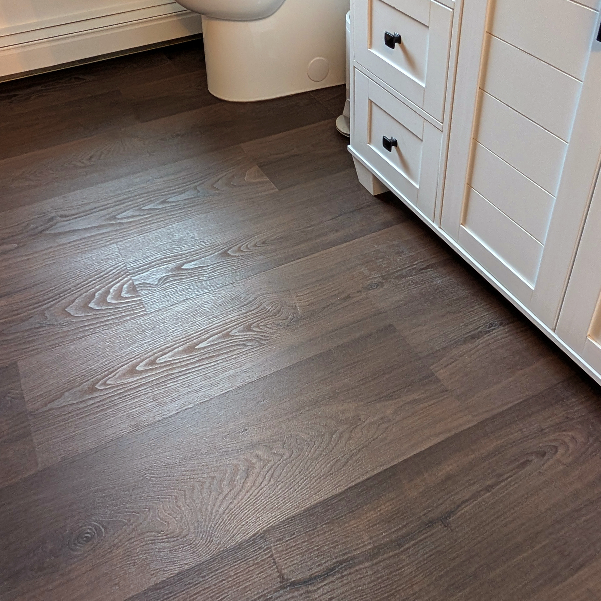 Vignette of Burnt Butter Walnut vinyl plank flooring in a bathroom