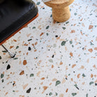 Close up of Allure terrazzo LVT floor with a chair and stool in the foreground