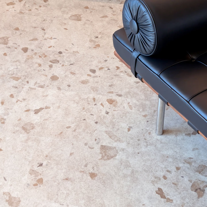 Black leather MCM bench on a terrazzo vinyl tile floor
