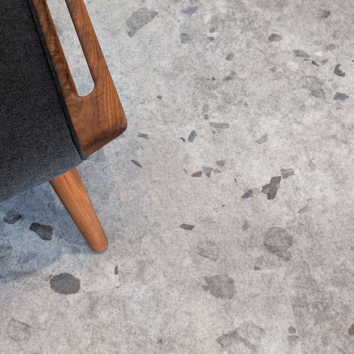 Close up of Galaway Grey terrazzo MCM flooring with wooden chair