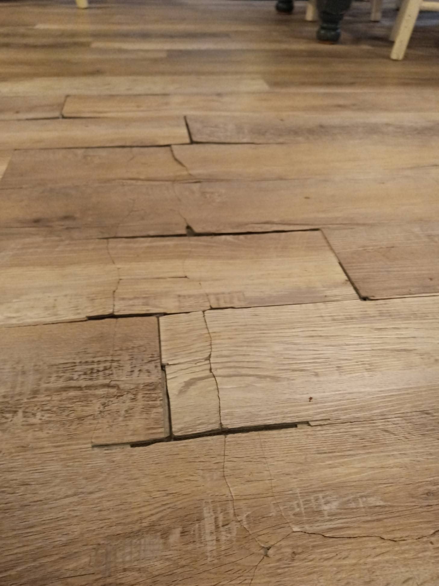 cheap thin brittle SPC flooring that's cracked apart in a ktichen
