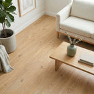 Living room with wooden flooring, a sofa, and decorative items.