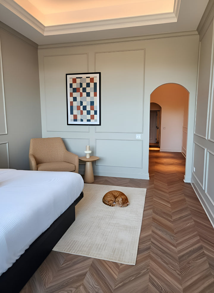 Peach Crisp Pine installed in a modern bedroom with a bed, armchair, and abstract art on the wall.