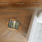 Allure chevron flooring pattern in peach crisp pine with white modern chair and side table with forest book.