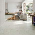 Living room with two people sitting on a couch and a dog lying on the floor.