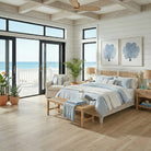 Beach-themed bedroom with ocean view, wooden floors, and coastal decor.