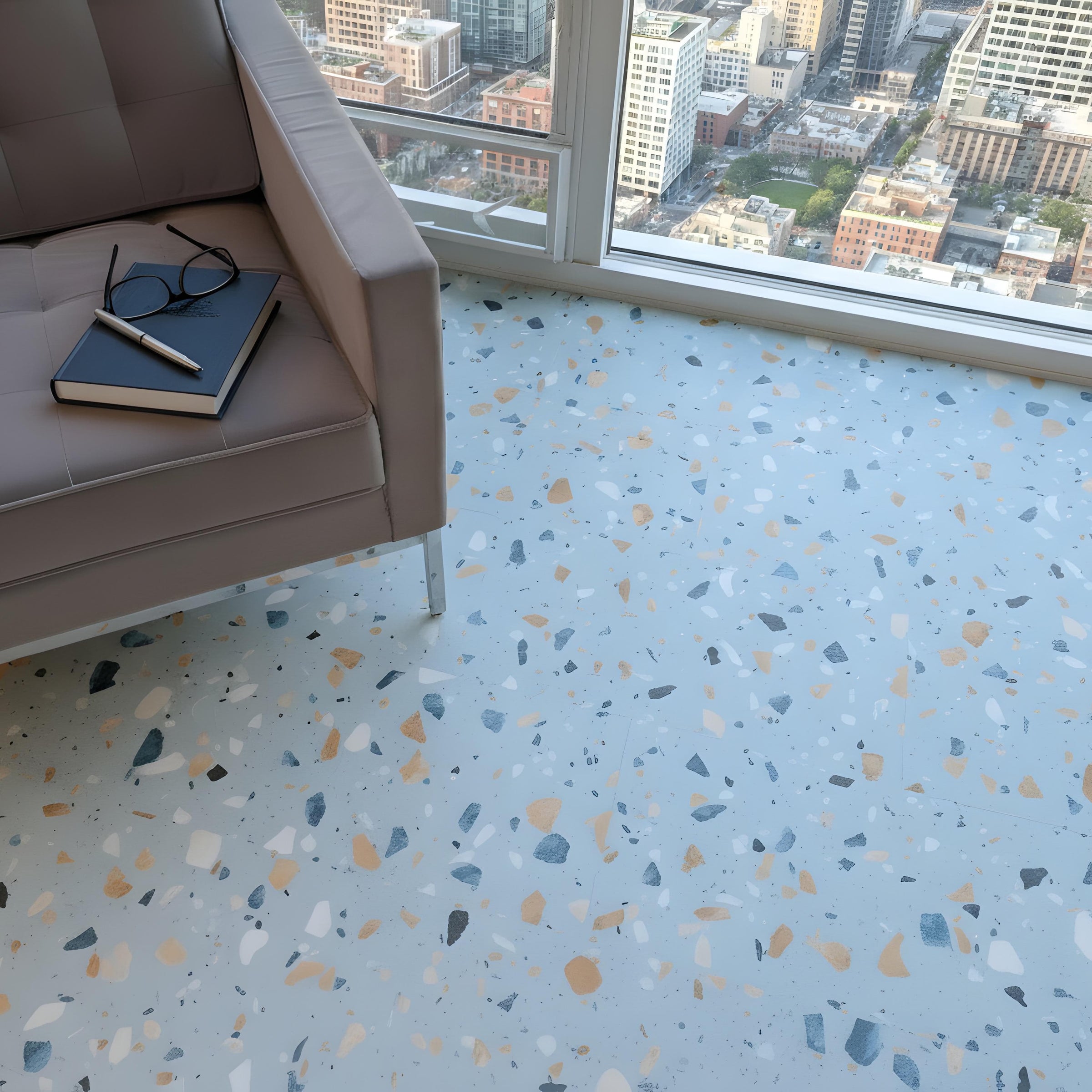 Allure Ultima Blue Agave Terrazzo tile flooring with city scape and gray modern chair, book and glasses.
