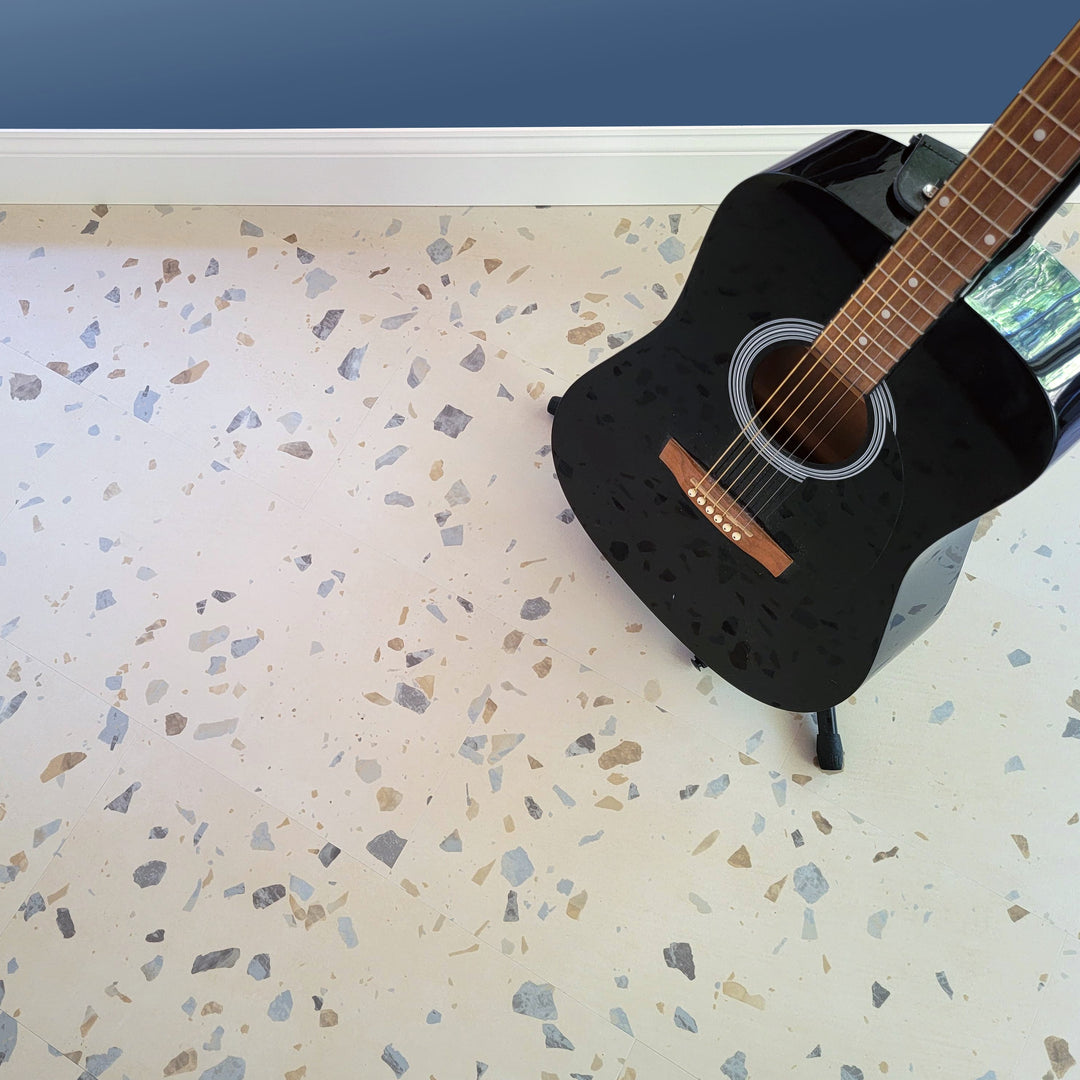 Black acoustic guitar on Allure terrazzo flooring