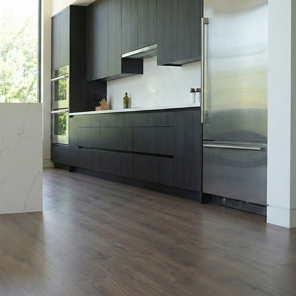 Modern kitchen with dark wood cabinets, stainless steel refrigerator and Allure Vanilla Latte Oak LVP flooring.