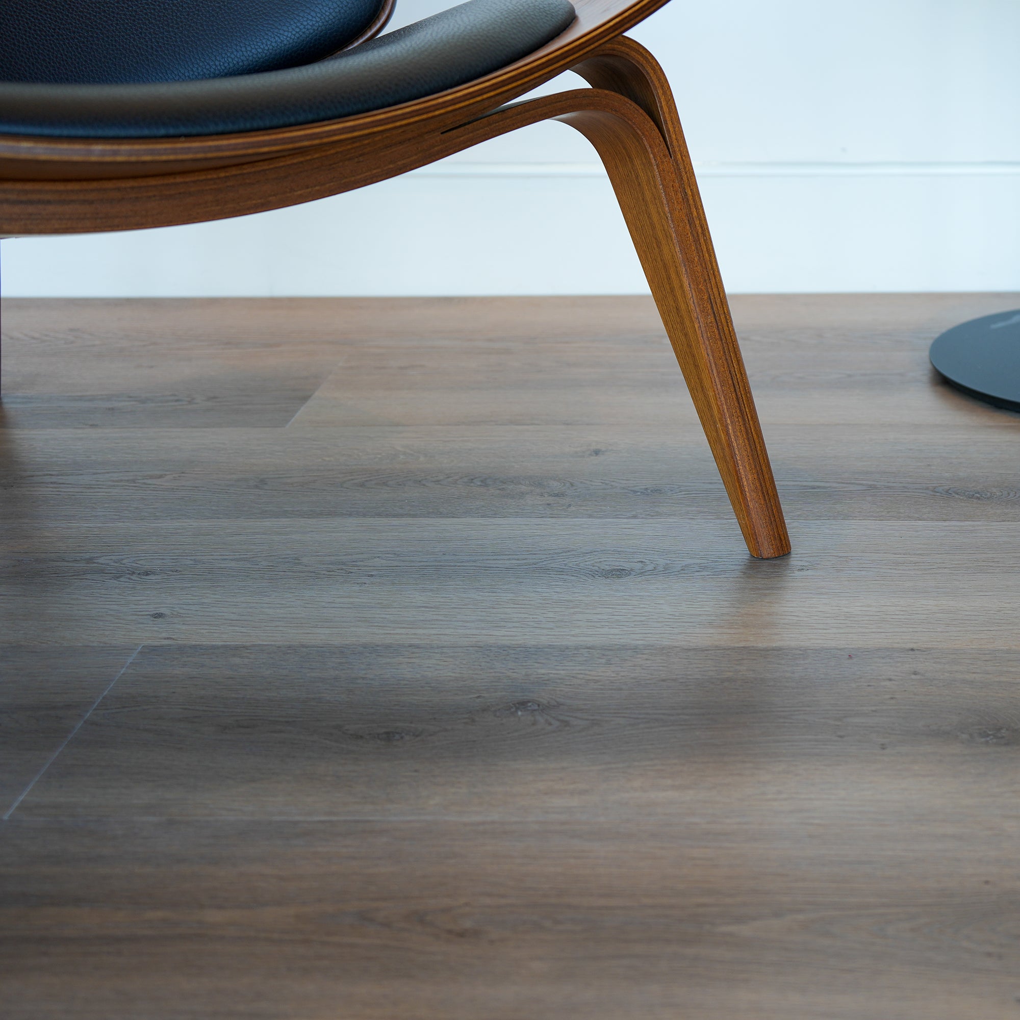 MCM Wooden chair on a Allure LVP floor with a blurred background