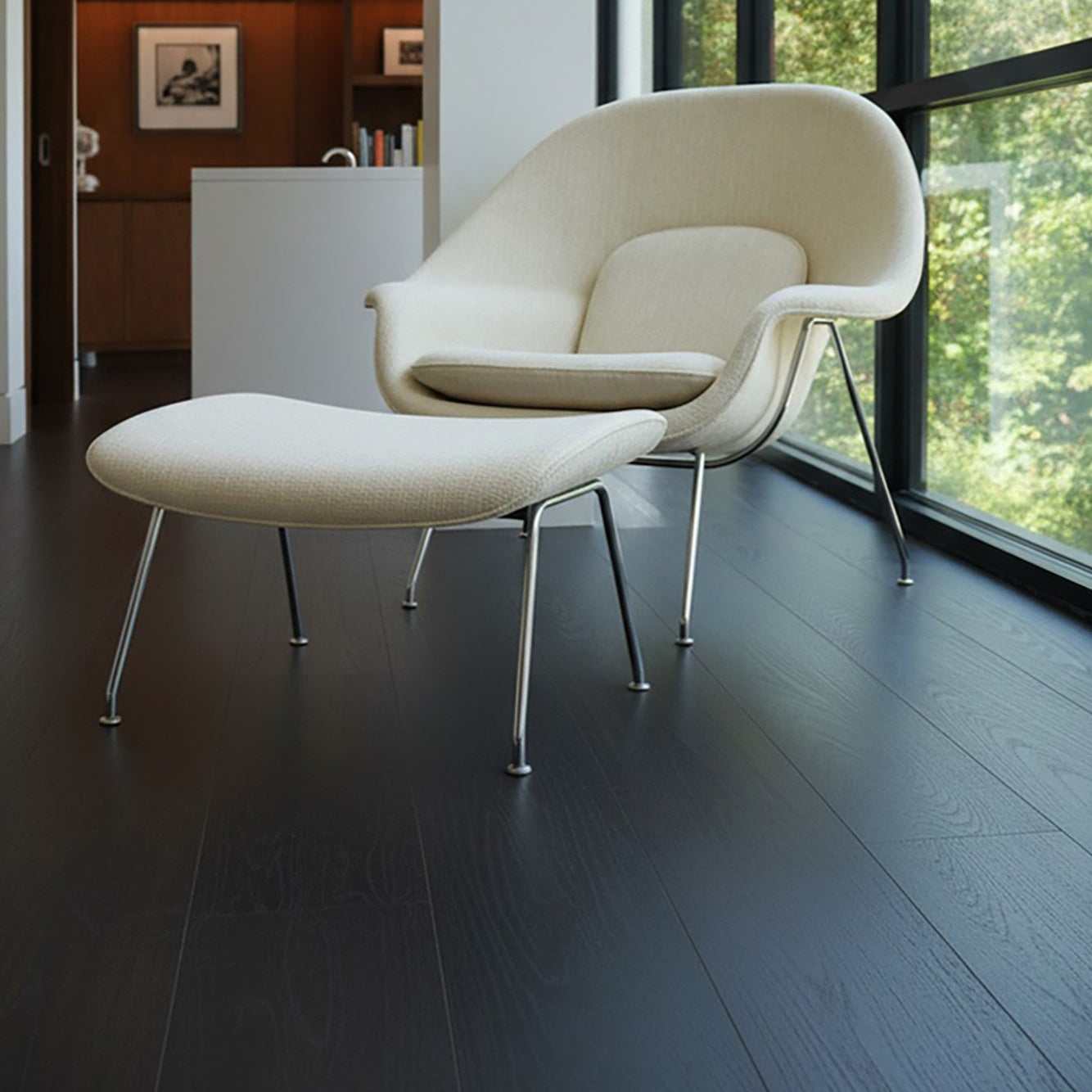 Modern white chair with ottoman in a room with velvet mocha Allure LVP floors and large windows