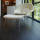 Modern white chair with ottoman in a room with velvet mocha Allure LVP floors and large windows