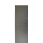 Close-up view of the back of a luxury vinyl plank, showcasing its textured surface and intricate design patterns, emphasizing durability and stability. The material appears robust and ready for installation, highlighting its quality as a flooring option