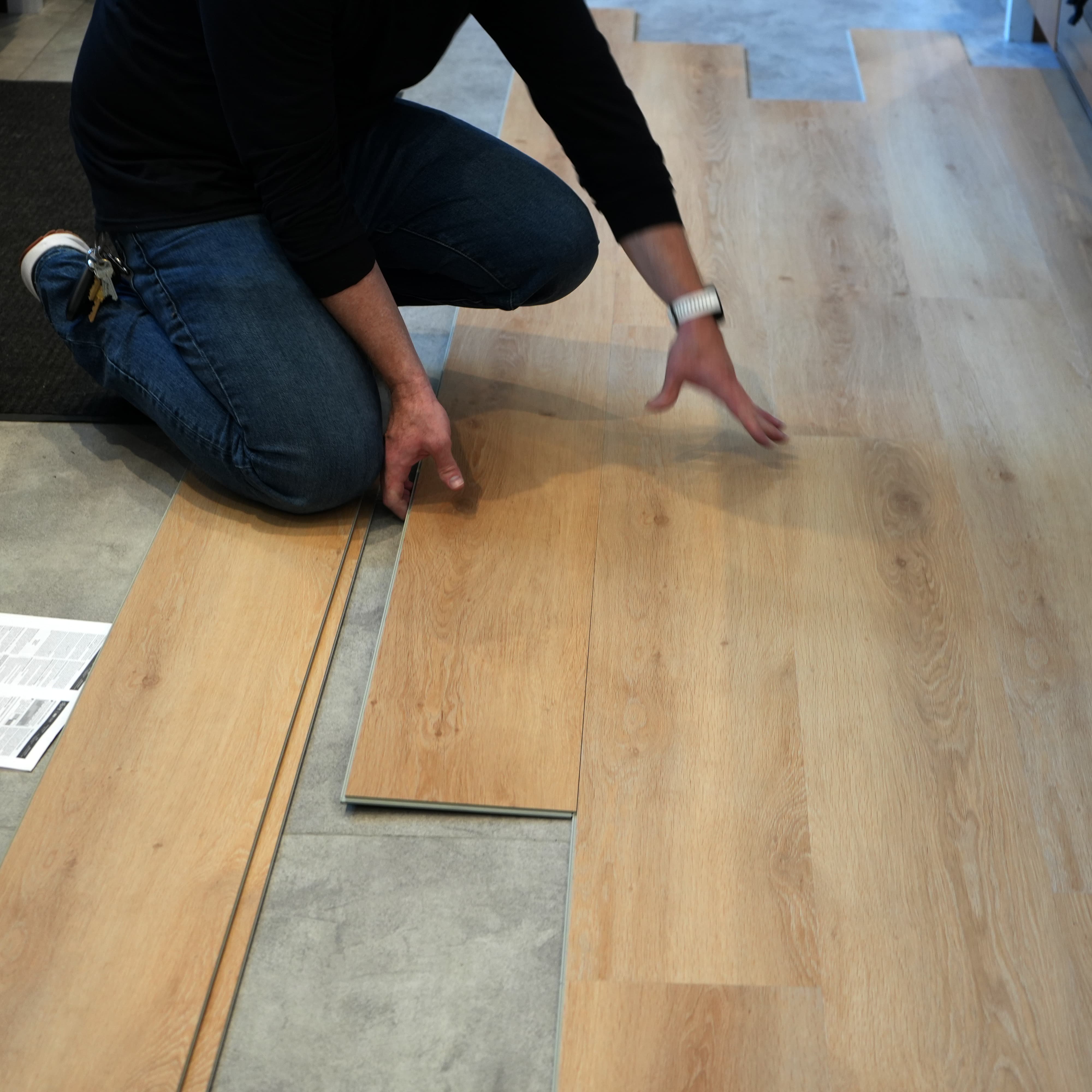 Person installing vinyl flooring on a concrete floor