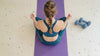 Woman in peaceful yoga pose in work out area with terrazzo flooring