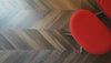 Dogs walking around on dark chevron floors circling a modern red chair